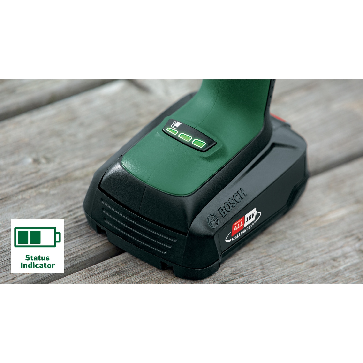Un elettroutensile Bosch verde e nero. Ha un indicatore di batteria e poggia su una superficie di legno. La batteria mostra due barre su tre.