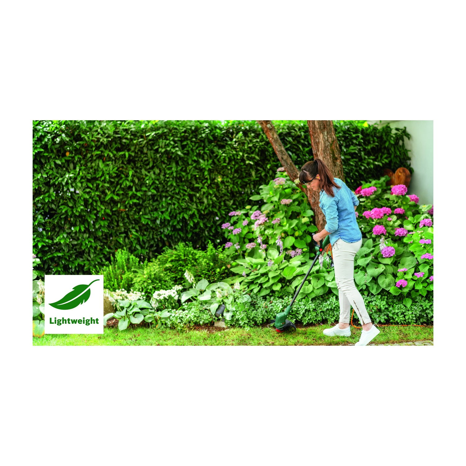 Una donna in giardino usa un tagliaerba. Siepe verde e fiori rosa sullo sfondo. Logo "Leggero" nell'angolo.
