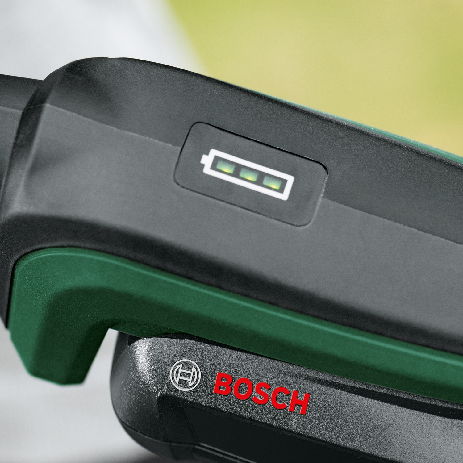 Primo piano di una batteria per utensili elettrici Bosch nera e verde. Un indicatore del livello della batteria mostra tre luci verdi. Il logo Bosch è rosso.