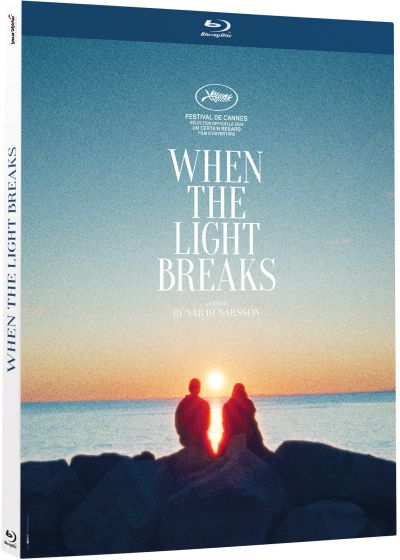 Blu-ray cover: twee figuren kijken naar de zonsondergang boven het water. Tekst luidt 'When the Light Breaks'.