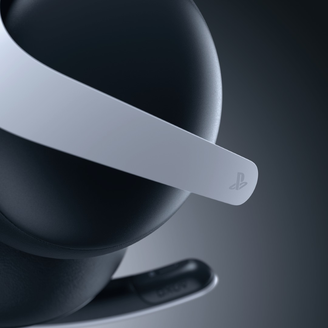 Zbliżenie czarno-białego zestawu słuchawkowego PlayStation 5 z logo PlayStation na pałąku. Tło jest szare.