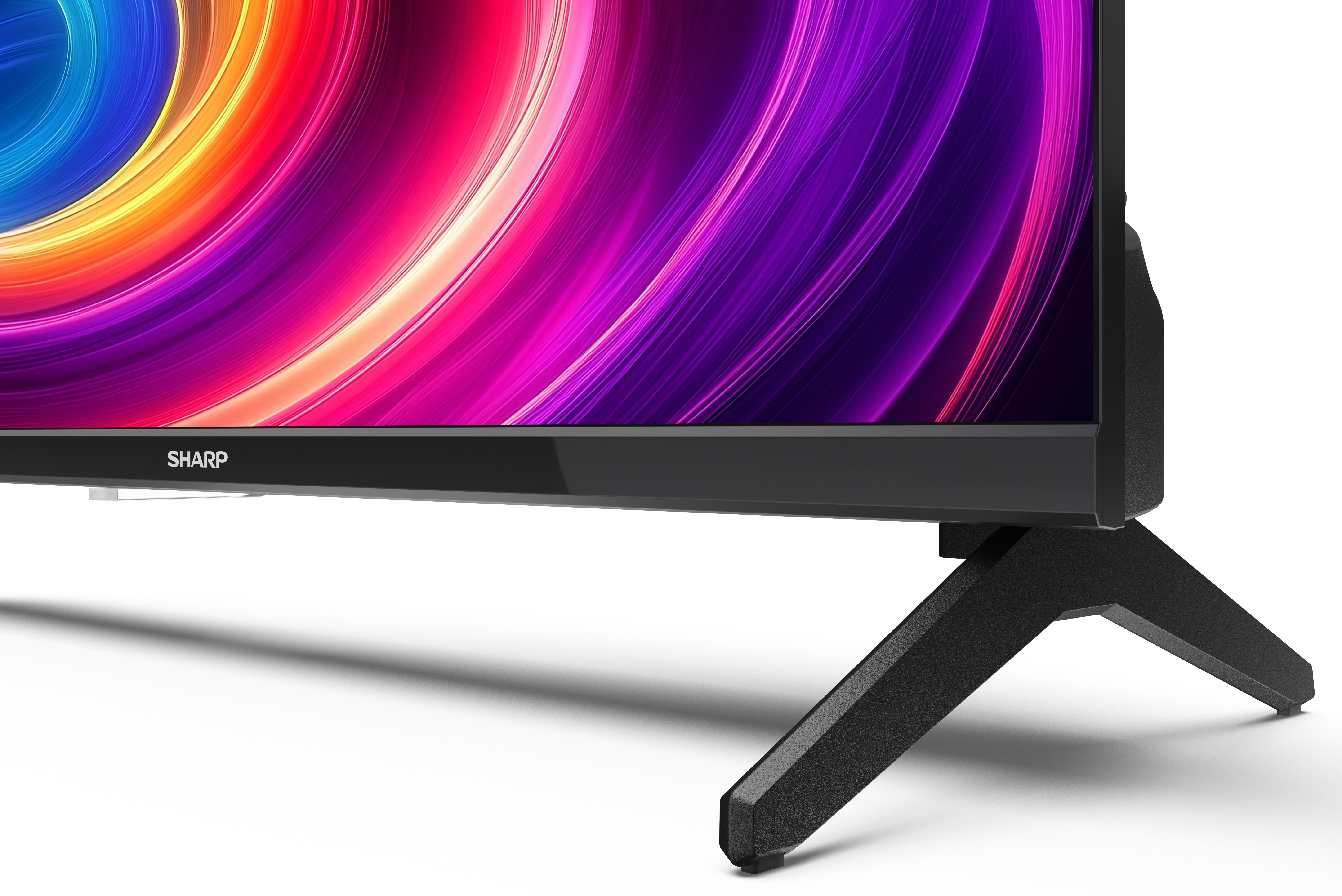 Telewizor Sharp z wirującym, kolorowym ekranem. Telewizor jest czarny, na białej powierzchni.