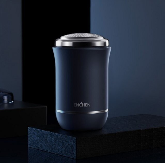 Ciemnoniebieska golarka elektryczna na czarnej powierzchni. Golarka ma srebrną górę i widoczną markę 'ENCHEN'.