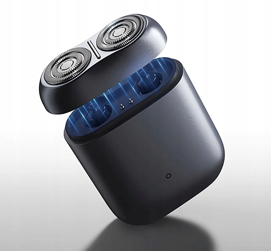 Zbliżenie czarnej golarki z otwartą górą. Górna część ma dwa srebrne, okrągłe ostrza. Podstawa jest czarna z niebieskim wnętrzem.