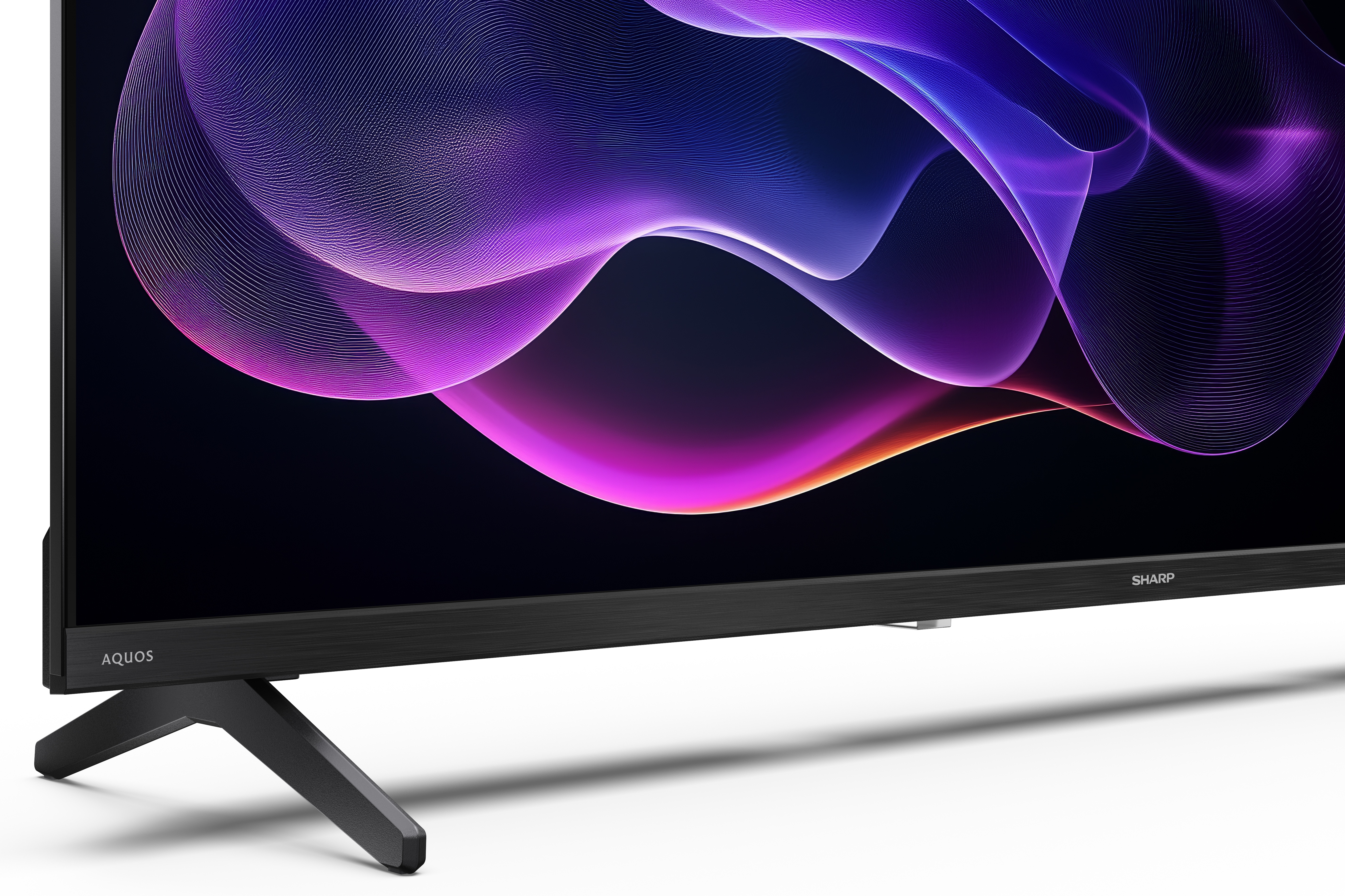 Czarny telewizor z dynamicznym, abstrakcyjnym wyświetlaczem fioletowych i różowych linii. Telewizor stoi na czarnym stojaku.