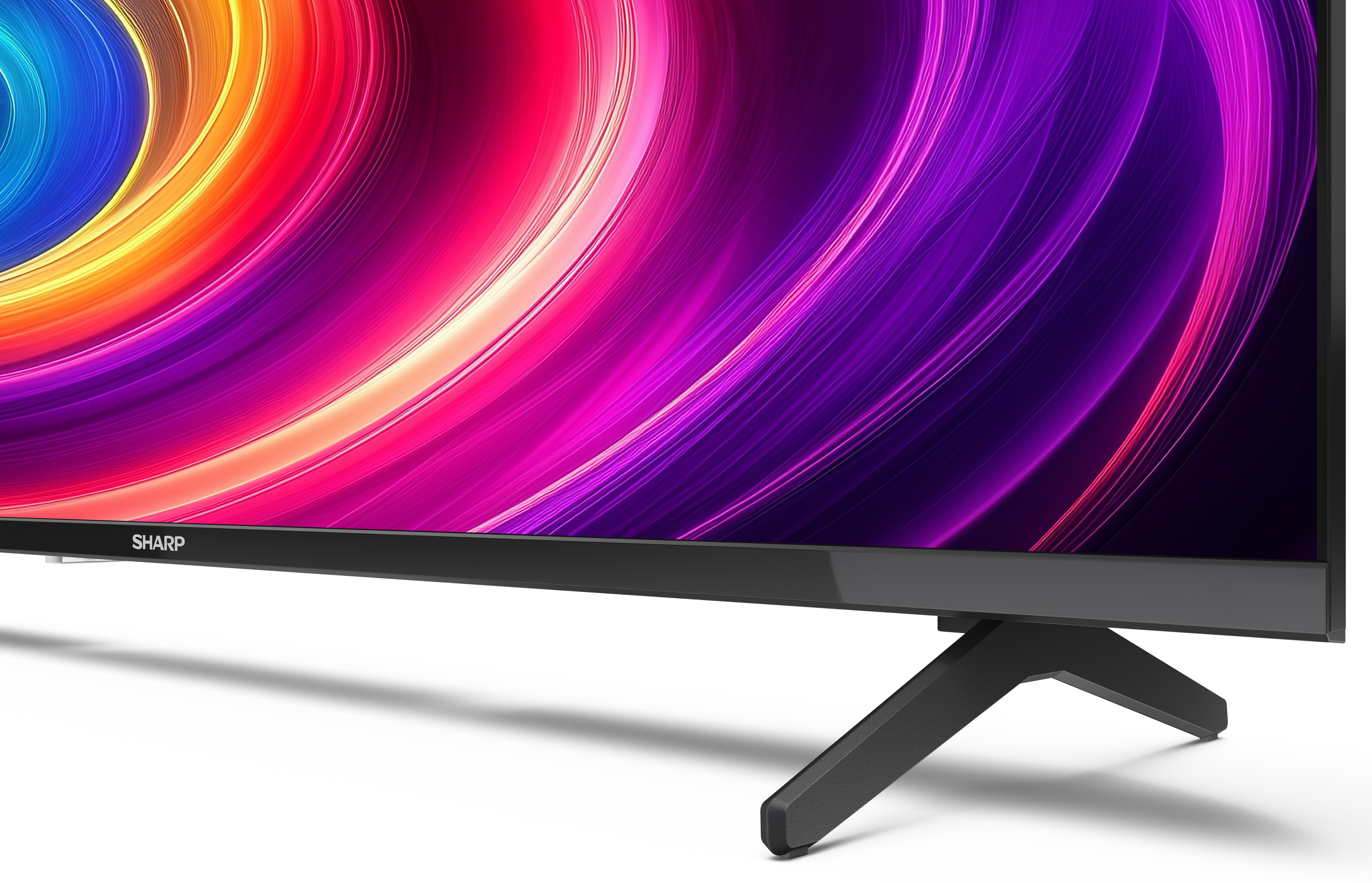 Czarny telewizor Sharp z kolorowym, abstrakcyjnym wyświetlaczem. Telewizor ma czarną podstawę i białe tło.