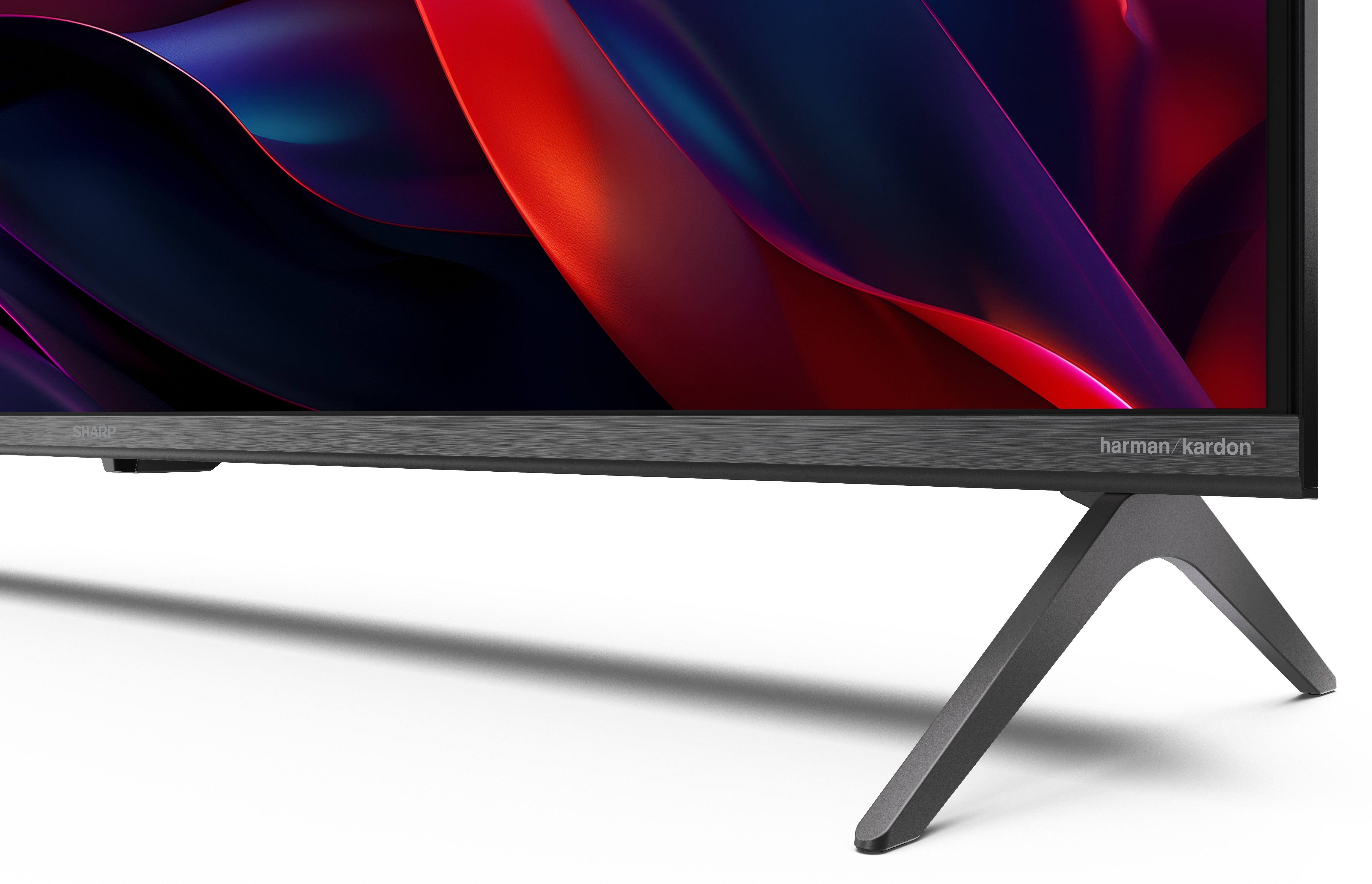 Zbliżenie telewizora. Ekran wyświetla sztukę abstrakcyjną. Telewizor ma ciemną ramę i szary stojak.