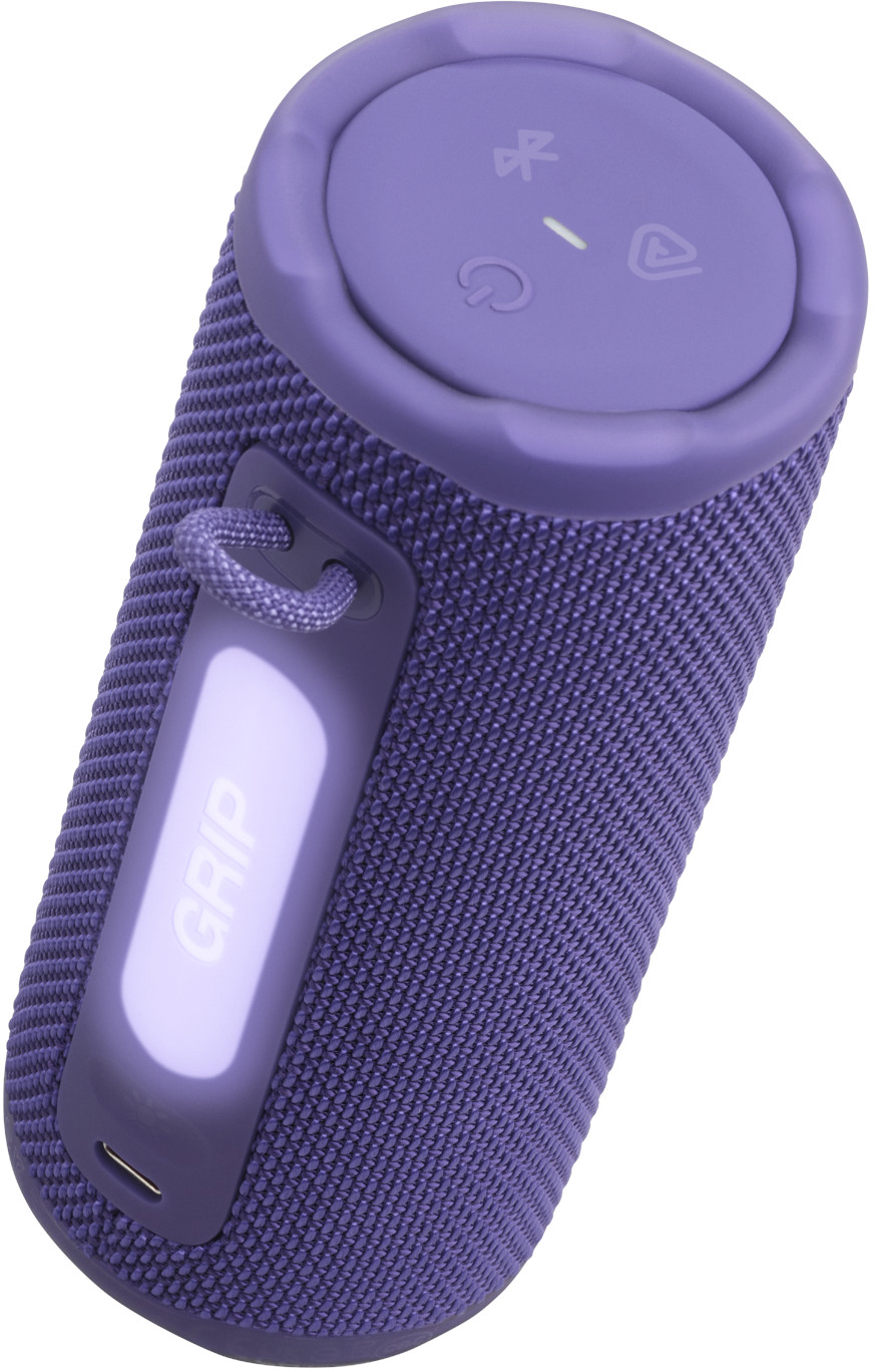 Un haut-parleur violet avec le mot 'GRIP' sur un panneau latéral. Il possède des boutons de commande et une boucle pour une sangle.
