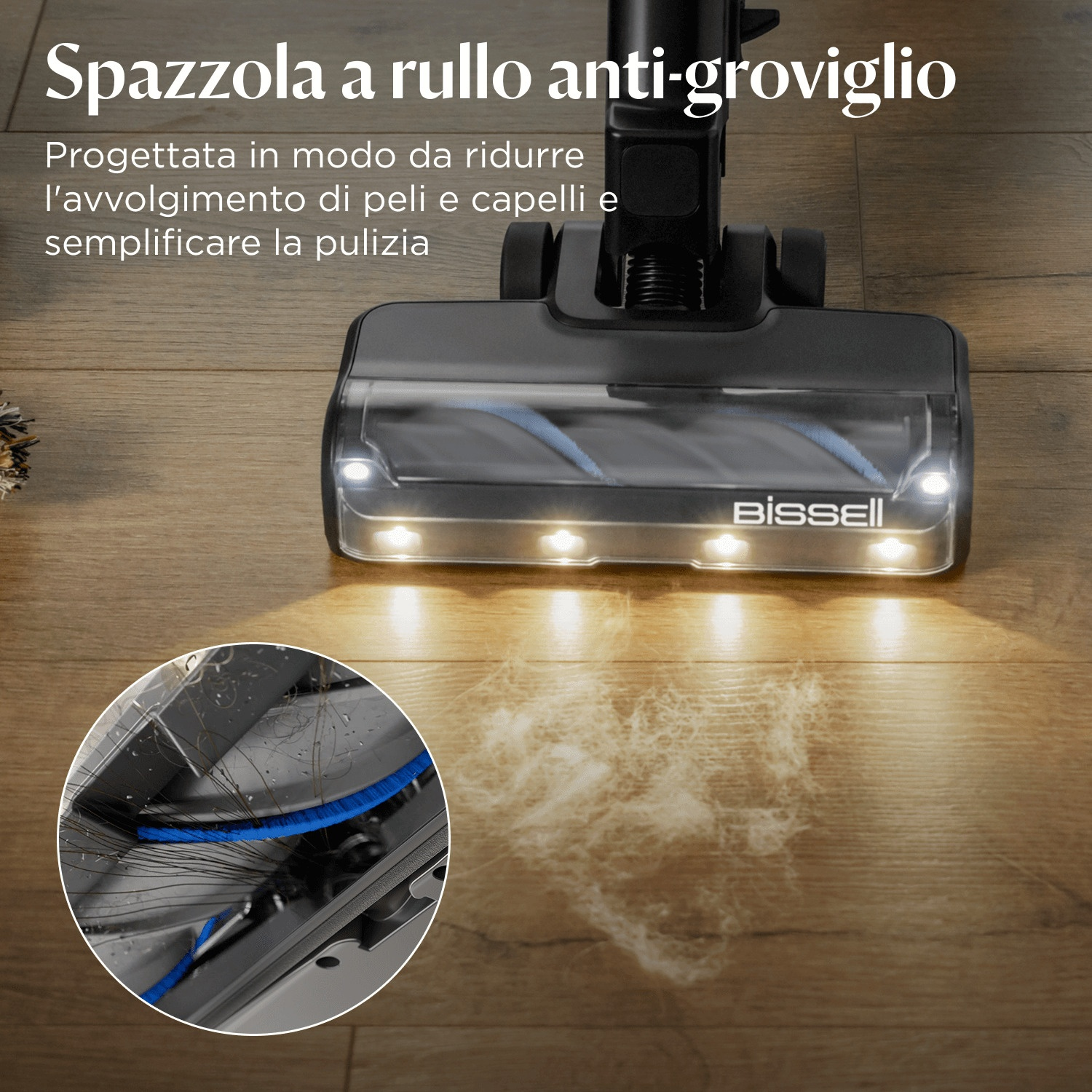 Una testina di aspirapolvere nera su un pavimento in legno, con un primo piano della sua spazzola. La testina è illuminata.
