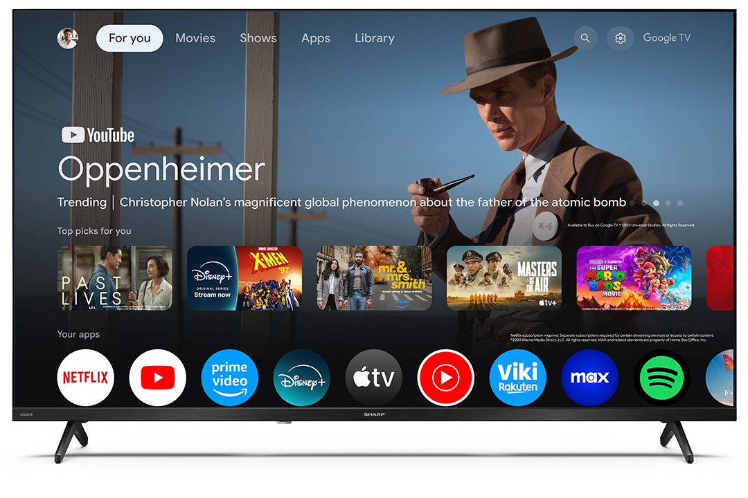 Egy Sharp TV filmválasztó képernyőt jelenít meg. Egy kalapos férfi egy pipát tart. Olyan alkalmazások láthatók, mint a Netflix és a YouTube.