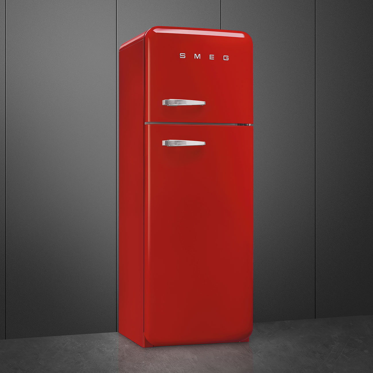 Ein roter SMEG-Kühlschrank steht vor einer grauen Wand. Der Kühlschrank hat silberne Griffe und der Markenname steht oben.