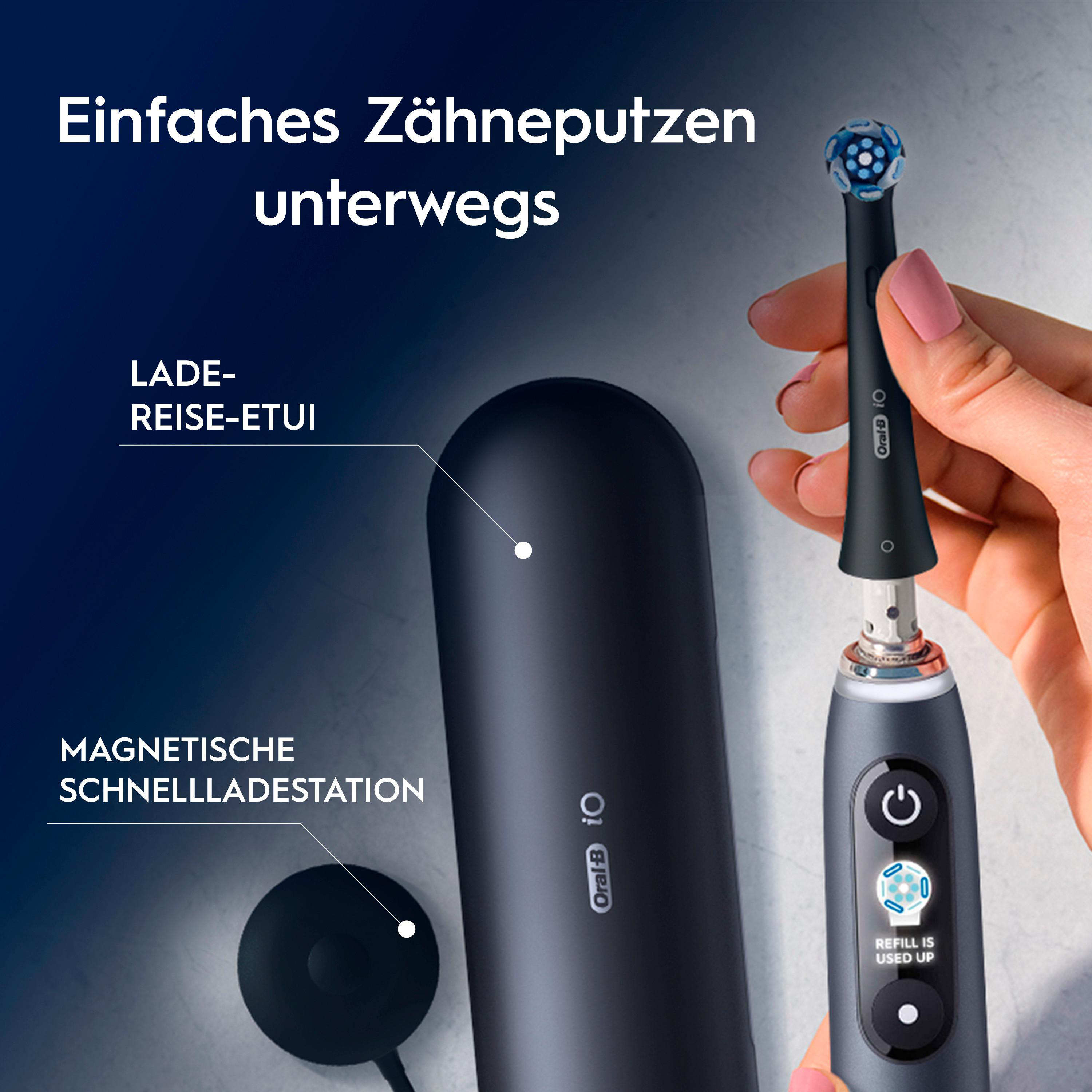 Eine Hand hält eine schwarze elektrische Zahnbürste mit blauem Kopf. Ein Ladeetui und eine Ladestation sind ebenfalls sichtbar.