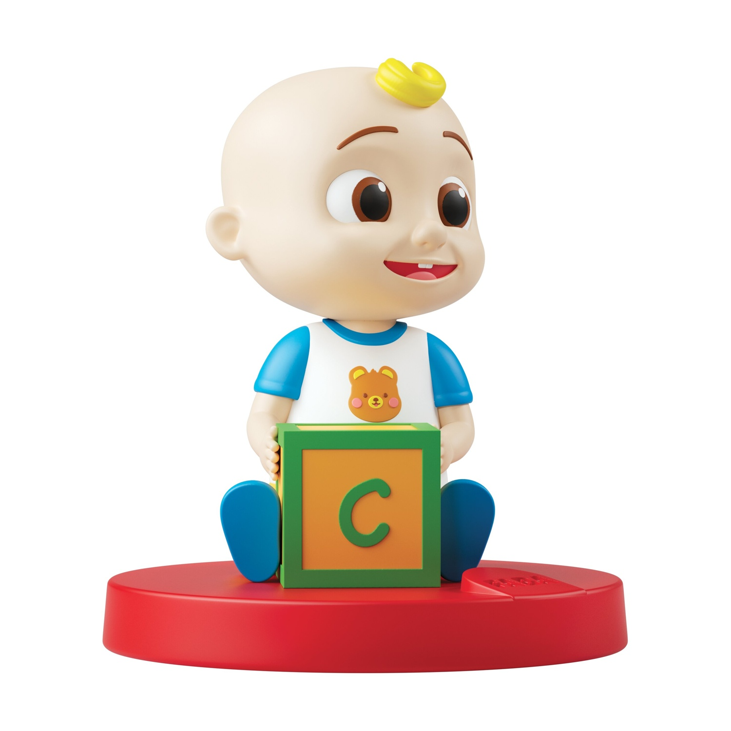 Una figura di un bambino giocattolo è seduta su una base rossa, che tiene in mano un blocco con la lettera 'C'. Il bambino indossa una camicia blu e bianca.