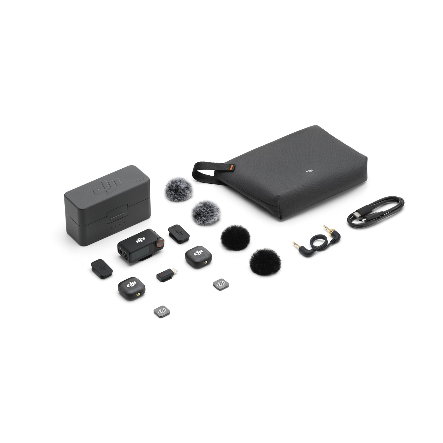 Una collezione di apparecchiature audio DJI su una superficie bianca. Include una custodia di ricarica, microfoni, una borsa e cavi.