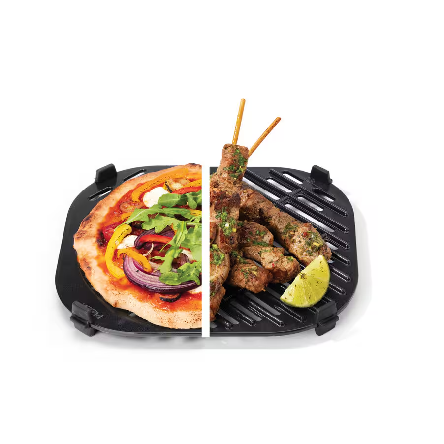 Fél pizza zöldségekkel és fél grillezett húsvirslik fekete grillen, egy lime szelettel. Fehér háttér.