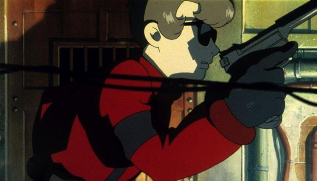 Eine animierte Figur in rotem Anzug und Sonnenbrille hält eine Waffe. Die Szene stammt aus einem Anime. Dunkler Hintergrund mit Rohren und Metall.