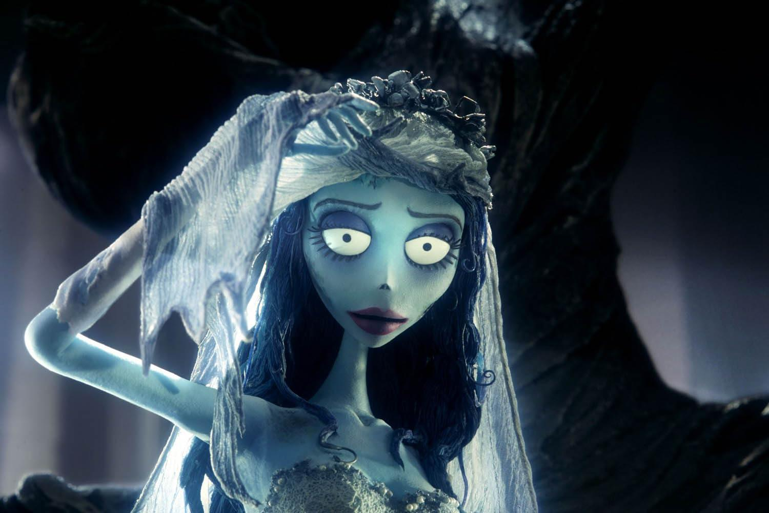 Eine blauhäutige animierte Braut aus 'Corpse Bride' mit Schleier, die traurig aussieht. Sie hat dunkelblaues Haar und trägt einen Blumenkranz.