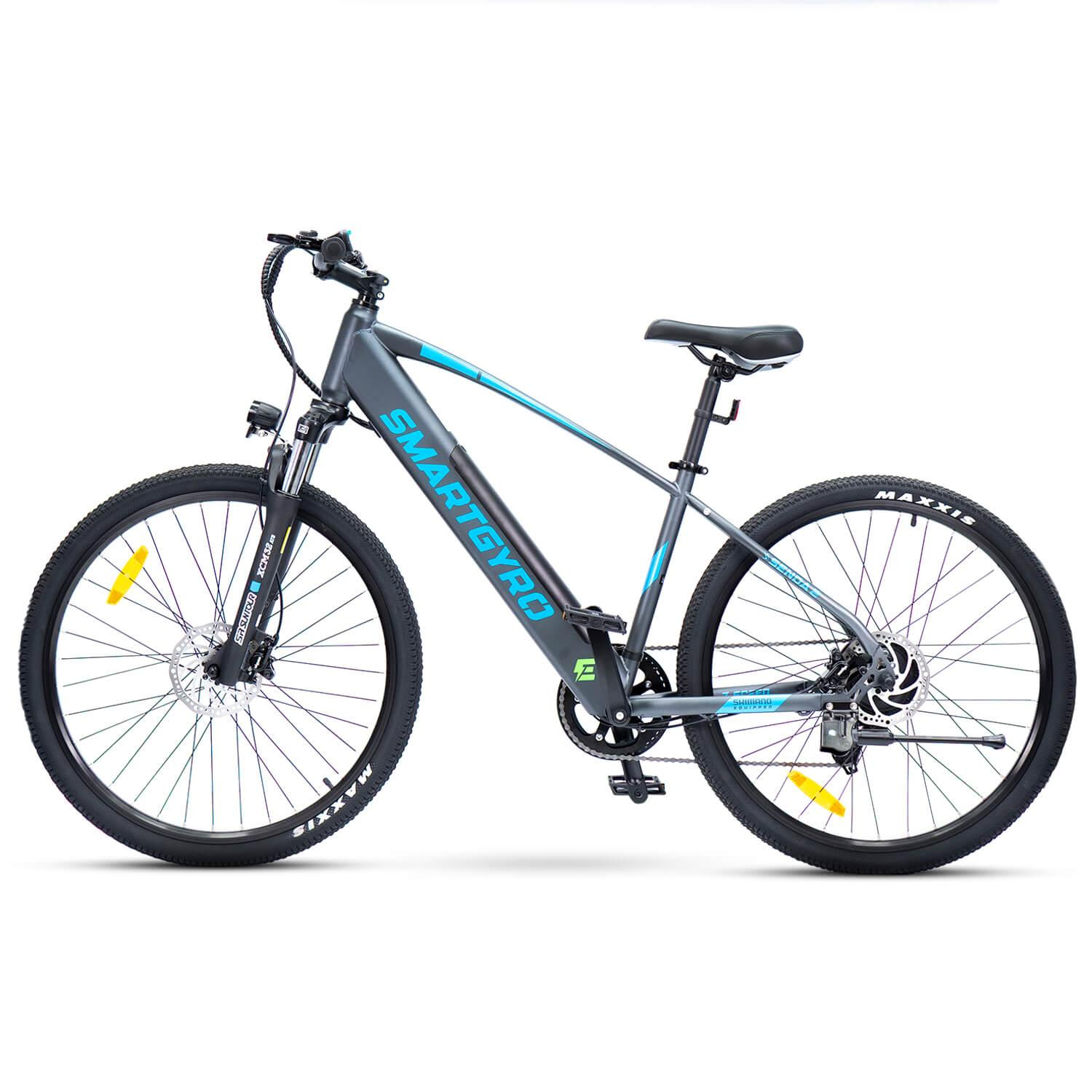 Una bicicleta eléctrica con marco gris y detalles azules. Tiene neumáticos negros, asiento negro y la marca 'SMARTGYRO'.