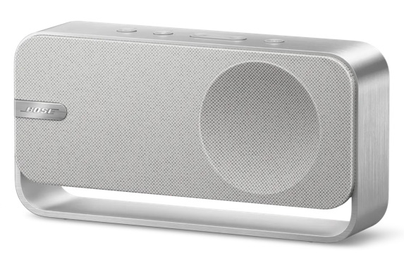 Srebrny i biały głośnik Bose. Posiada maskownicę głośnika, kilka przycisków na górze i zakrzywiony metalowy stojak.