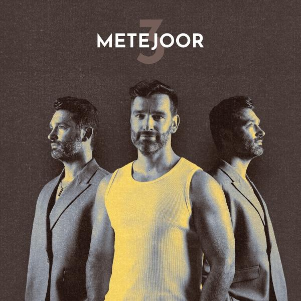 Trois hommes en rang, un en débardeur jaune, les autres en costumes, sur fond sombre. Le nom 'METEJOOR' est au-dessus.
