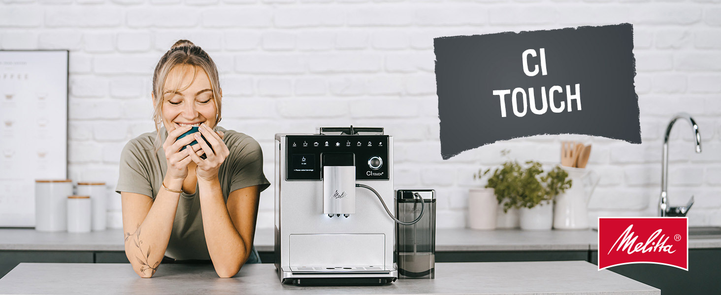 Bir kadın gülümsüyor, bir kahve makinesinin yanında mavi bir fincan tutuyor. Sahne, 'CI TOUCH' metniyle bir mutfak ortamı içeriyor.