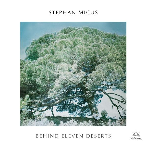 Albumcover: Großer Baum mit dichtem, hellgrünem Laub. Oben steht 'Stephan Micus'. Darunter 'Behind Eleven Deserts'.