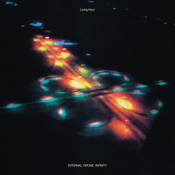 Abstraktes Bild von bunten Lichtern auf dunklem Hintergrund, möglicherweise eine Autobahn bei Nacht. Der Text 'Living Hour' ist sichtbar.