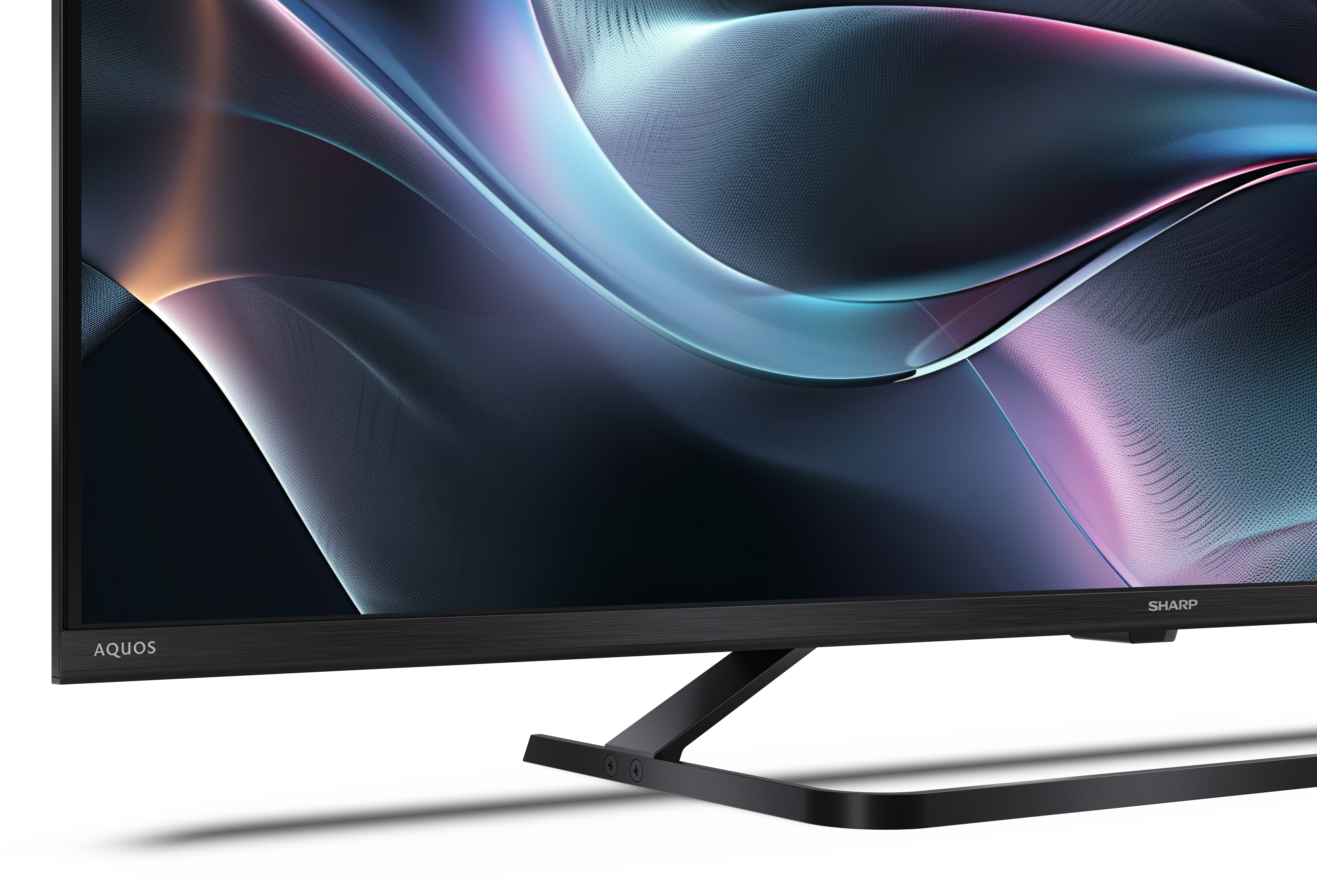 Telewizor Sharp Aquos wyświetla abstrakcyjny obraz w kolorach niebieskim, fioletowym i pomarańczowym. Telewizor ma czarną ramę i podstawę.