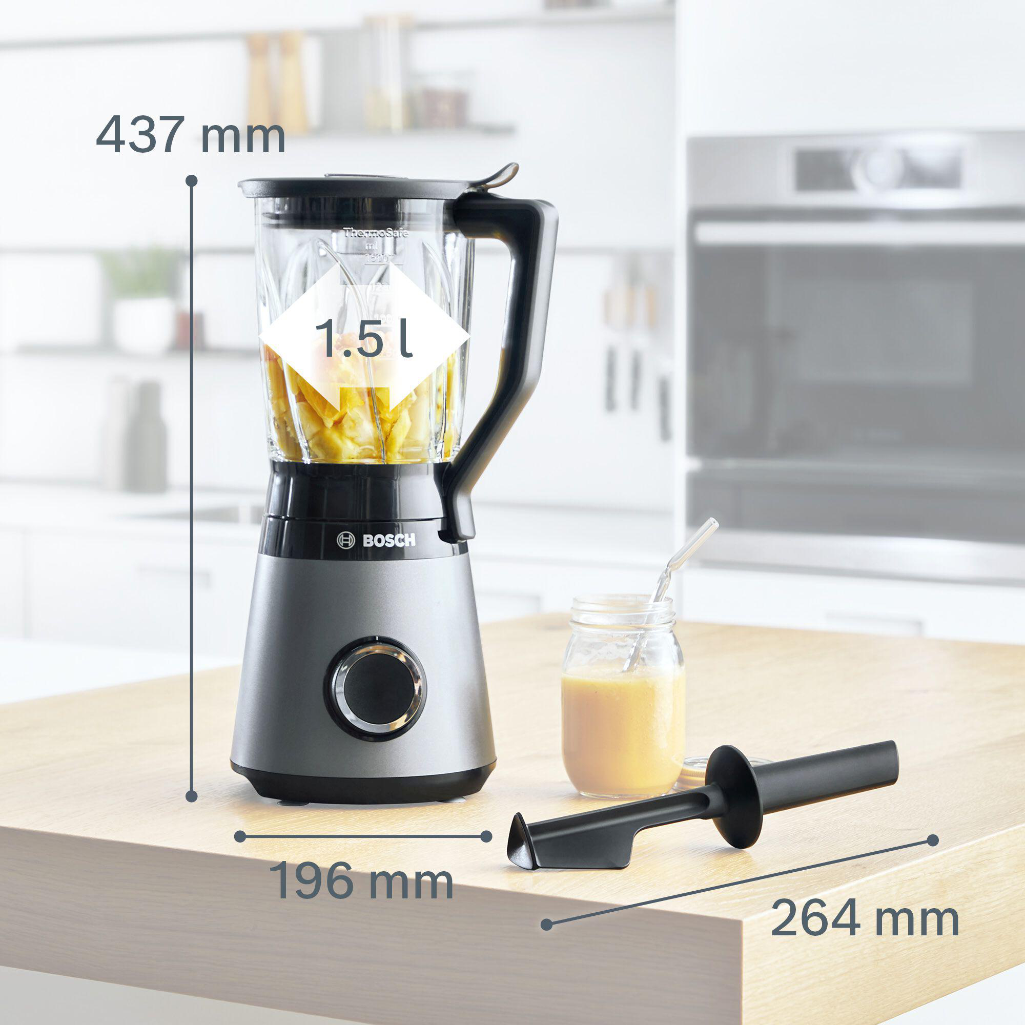 Mixer mit Früchten, einem Glas Saft und einem Werkzeug. Der Mixer ist silber und schwarz, mit Maßen.