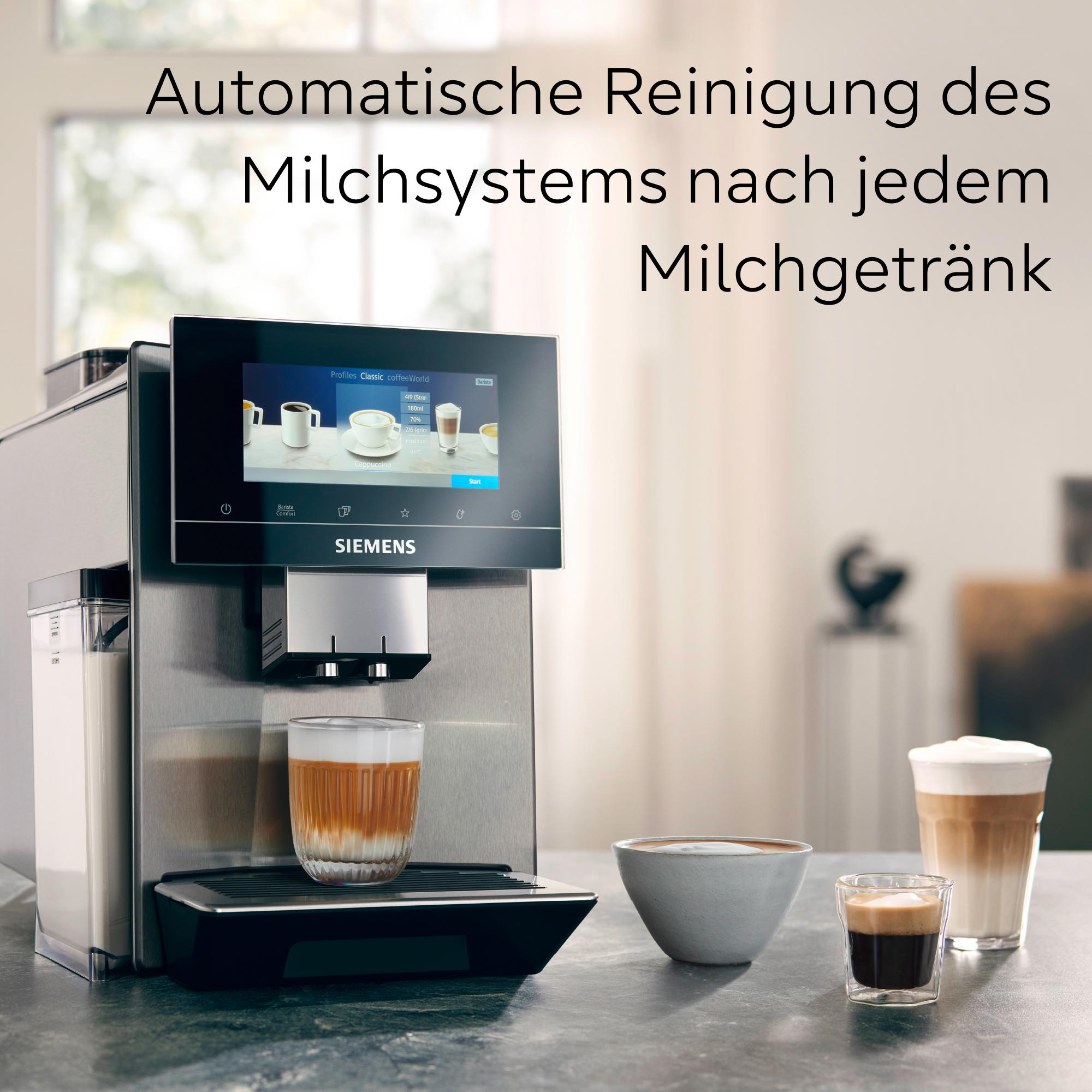 Eine silberne Kaffeemaschine mit Bildschirm, ein Glas Kaffee und zwei weitere Kaffeegetränke auf einem Tisch.