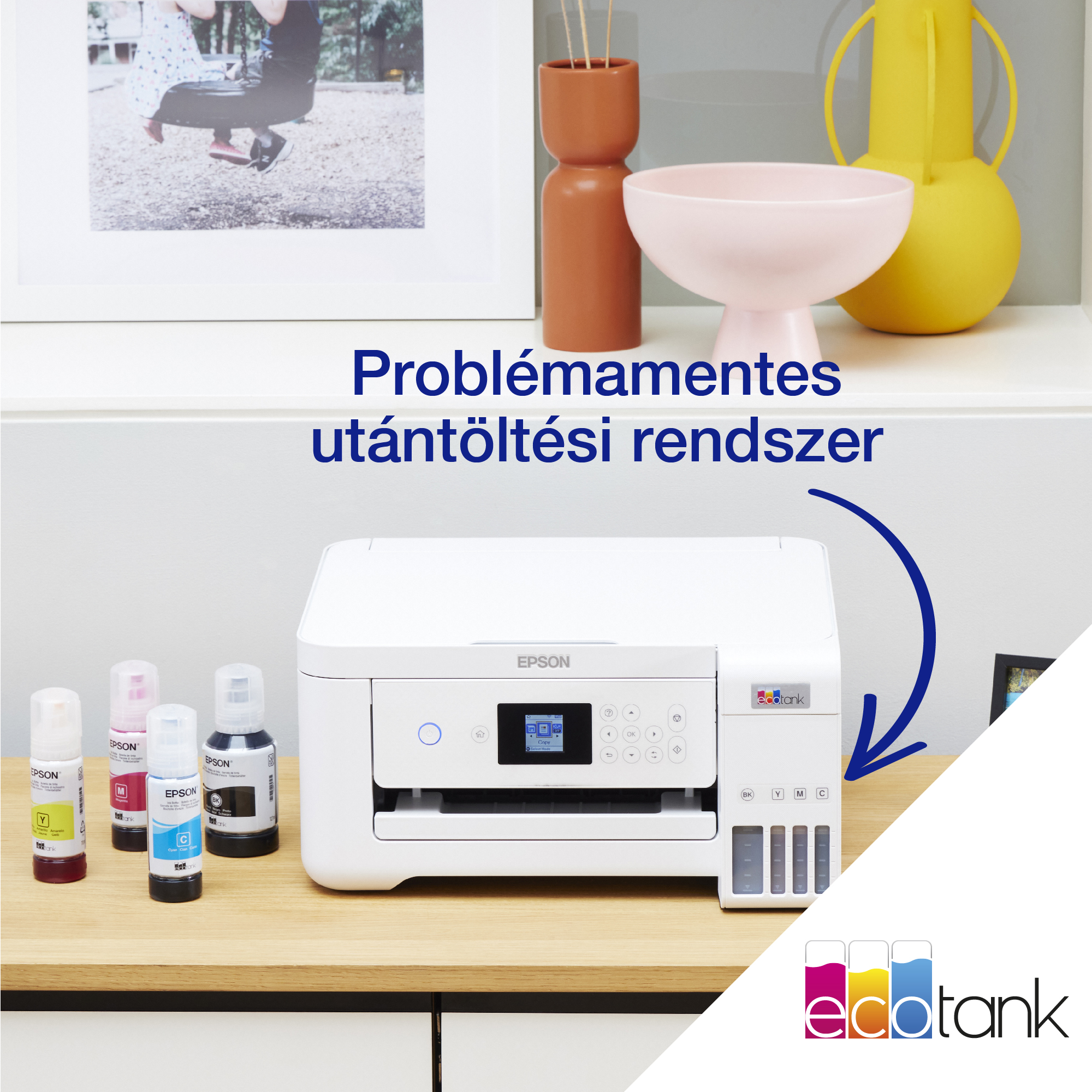 Egy fehér Epson nyomtató tintapalackokkal. A háttérben egy kép lóg. A szöveg a következő: „Problémamentes utántöltő rendszer”.