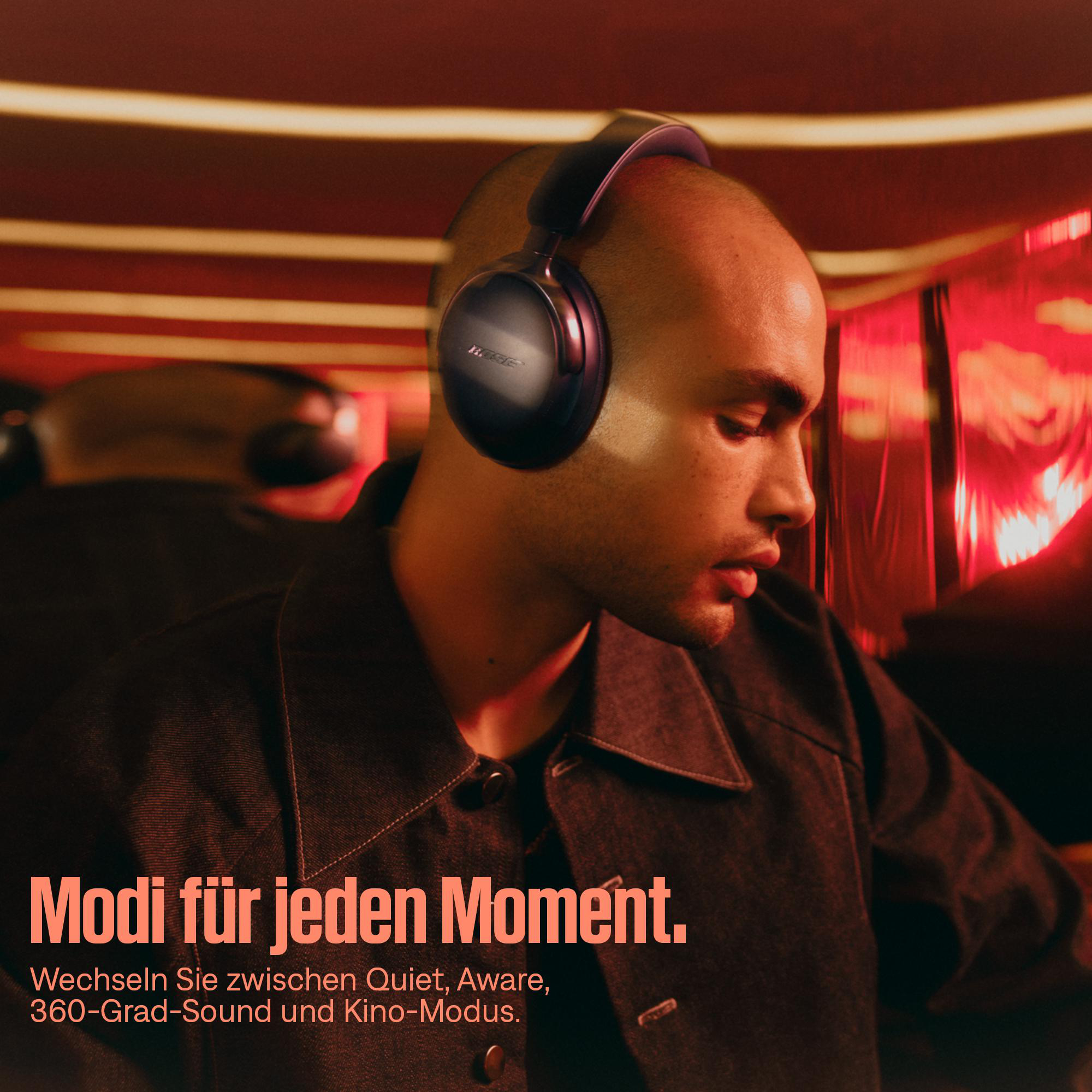 Ein Mann mit Kopfhörern, der nach unten schaut. Rote und orange Farbtöne dominieren den Hintergrund. Text unten.