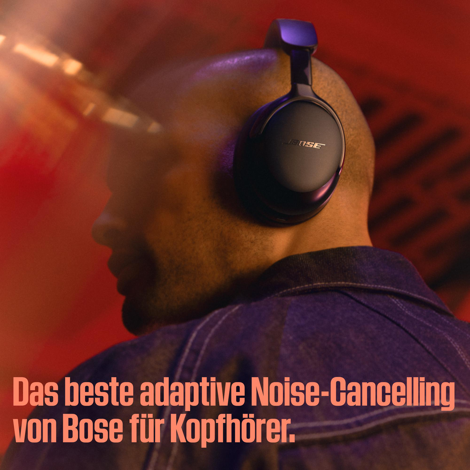 Eine Person mit schwarzen Bose-Kopfhörern. Der Hintergrund ist rot. Text: 'Das beste adaptive Noise-Cancelling von Bose für Kopfhörer'.