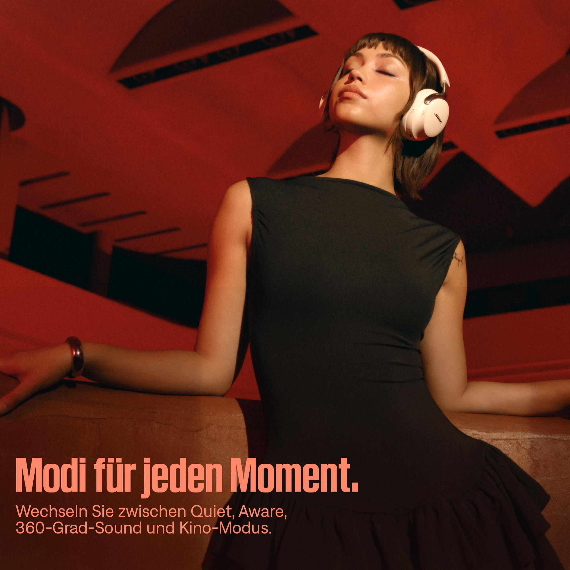 Frau mit weißen Kopfhörern, Augen geschlossen, schwarzes Kleid, vor rotem Hintergrund. Text: Modi für jeden Moment.
