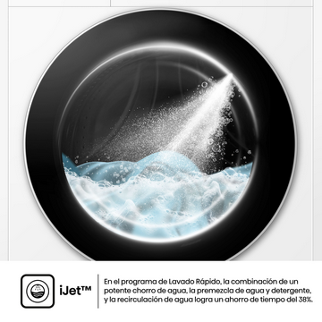 Un tambor de lavadora con agua y espuma. Un chorro de agua entra en el tambor. La puerta de la máquina es negra.
