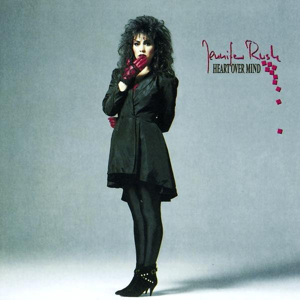 Jennifer Rush az album borítóján, fekete ruhában és piros kesztyűben, a 'Heart Over Mind' címmel.