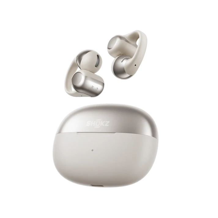 Un par de auriculares inalámbricos beige y plateados y un estuche de carga. Los auriculares están encima del estuche.