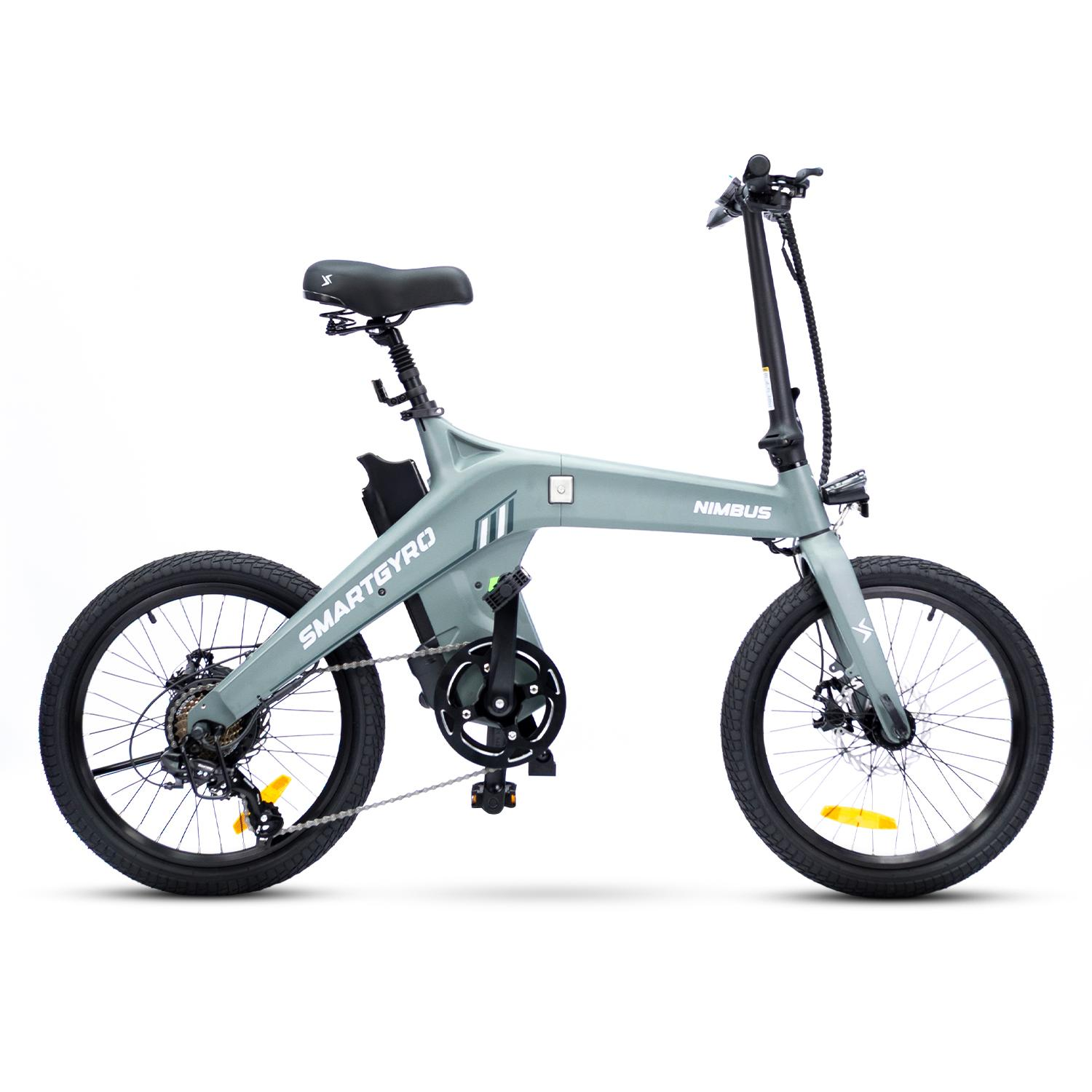 Una bicicleta eléctrica Nimbus Smartgyro gris claro sobre fondo blanco. La bicicleta tiene neumáticos negros, un asiento negro y la marca es visible.