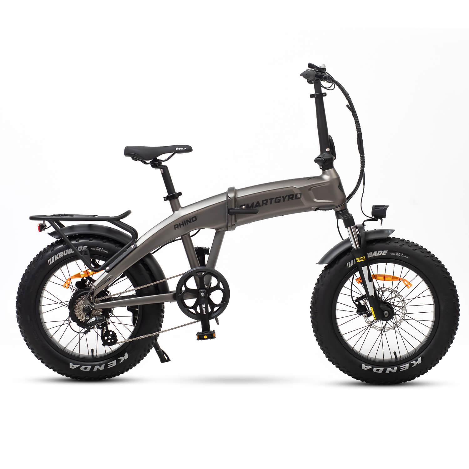 Una bicicleta eléctrica Smartgyro Rhino gris con neumáticos y asiento negros sobre fondo blanco. La bicicleta está plegada.