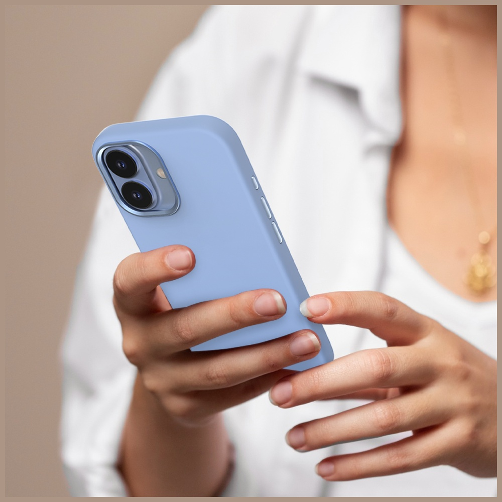 Osoba trzyma jasnoniebieski smartfon. Telefon ma etui. Osoba ma na sobie białą koszulę i naszyjnik.