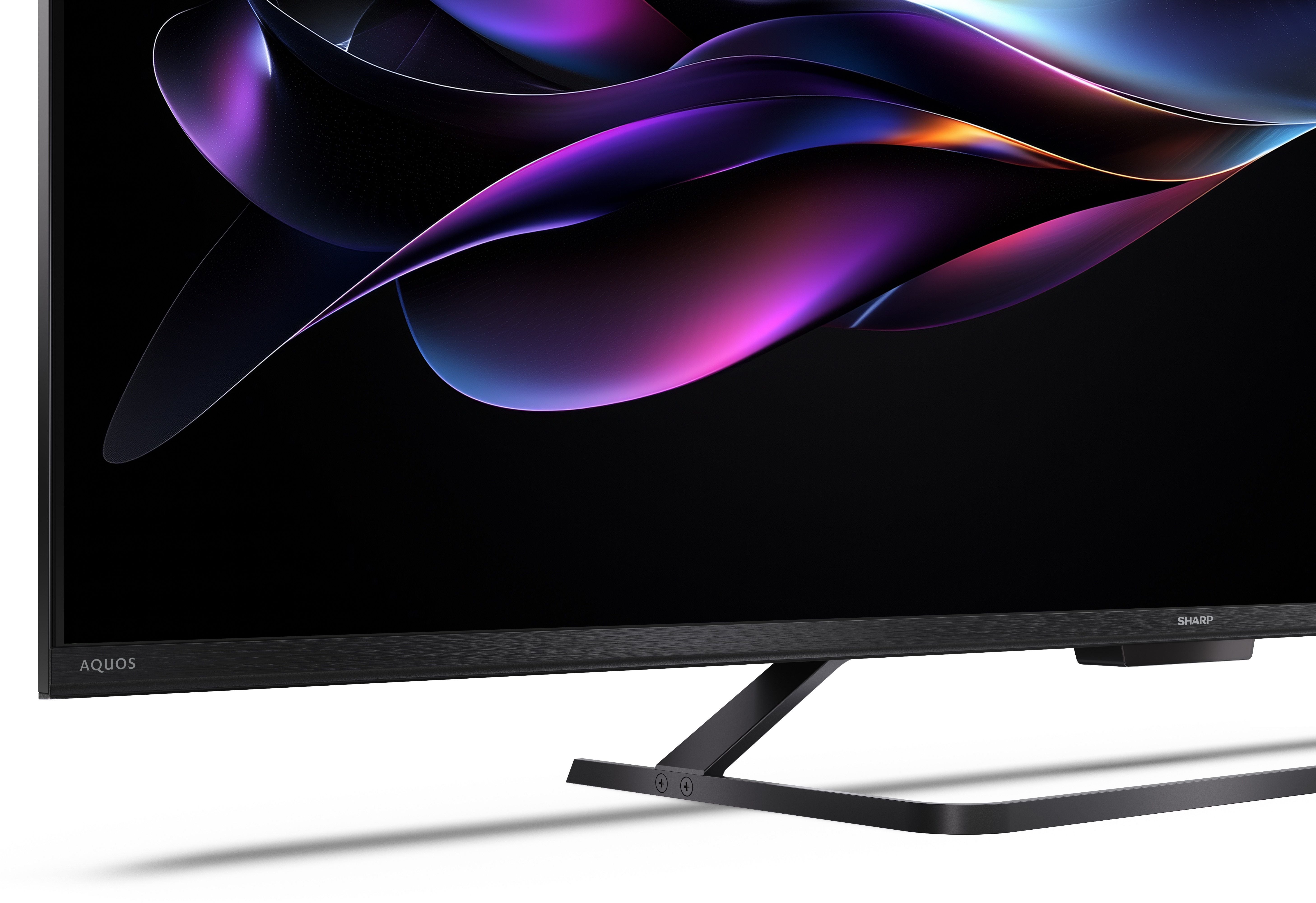 Telewizor Sharp Aquos z czarną ramą i podstawą. Ekran wyświetla kolorowy, abstrakcyjny wzór.