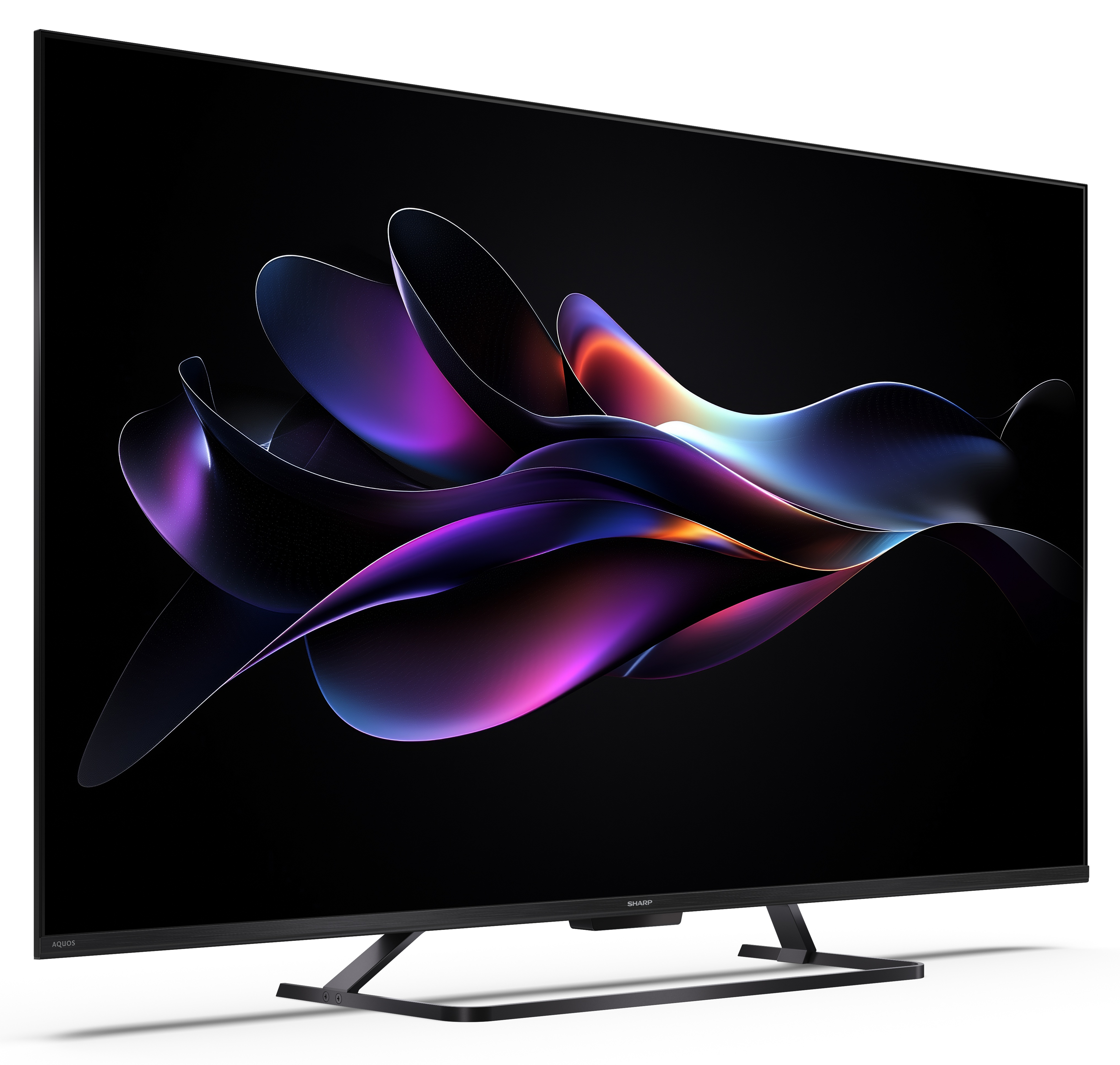 Duży ekran telewizora wyświetla kolorowy, abstrakcyjny wzór na czarnym tle. Telewizor stoi na białej powierzchni.