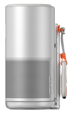 Srebrny głośnik z czarną siatką, pomarańczowym paskiem i pilotem. Widok z boku, białe tło.