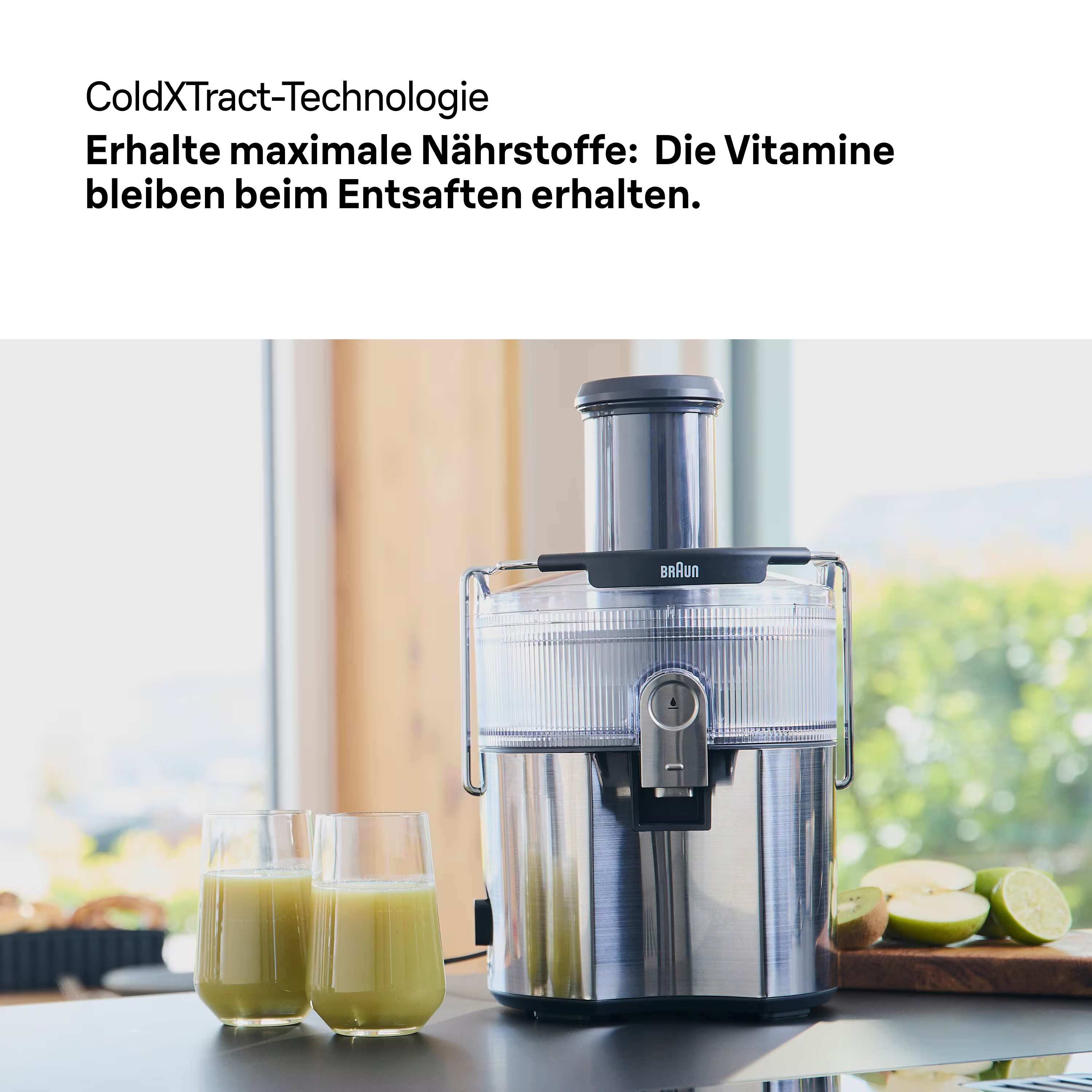 Ein Entsafter mit zwei Gläsern Saft. Kiwi- und Apfelscheiben auf einem Holzbrett sind ebenfalls sichtbar.
