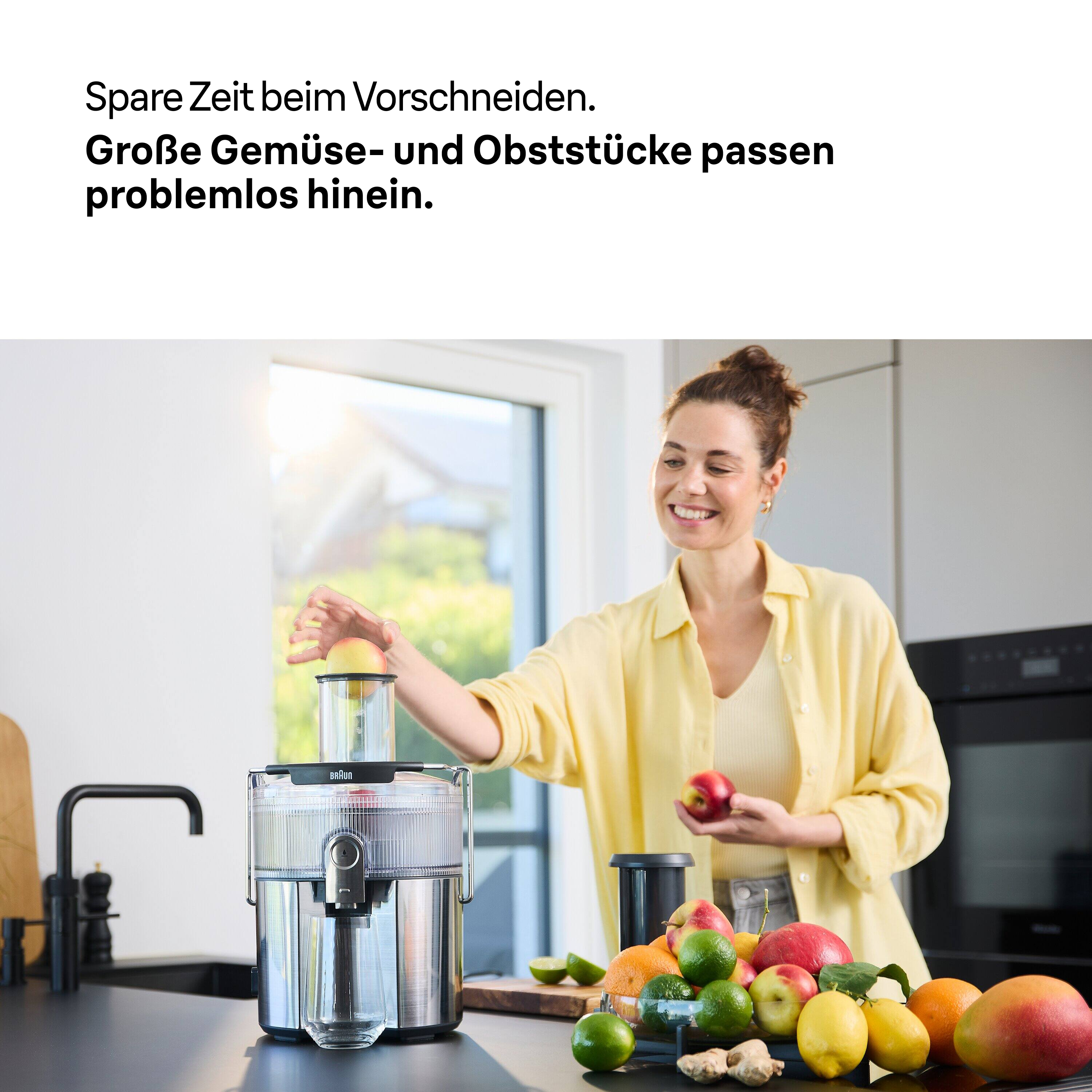 Frau gibt Apfel in Entsafter. Obst und Gemüse liegen auf der Theke. Der Text lautet: Zeit sparen beim Vorschneiden.