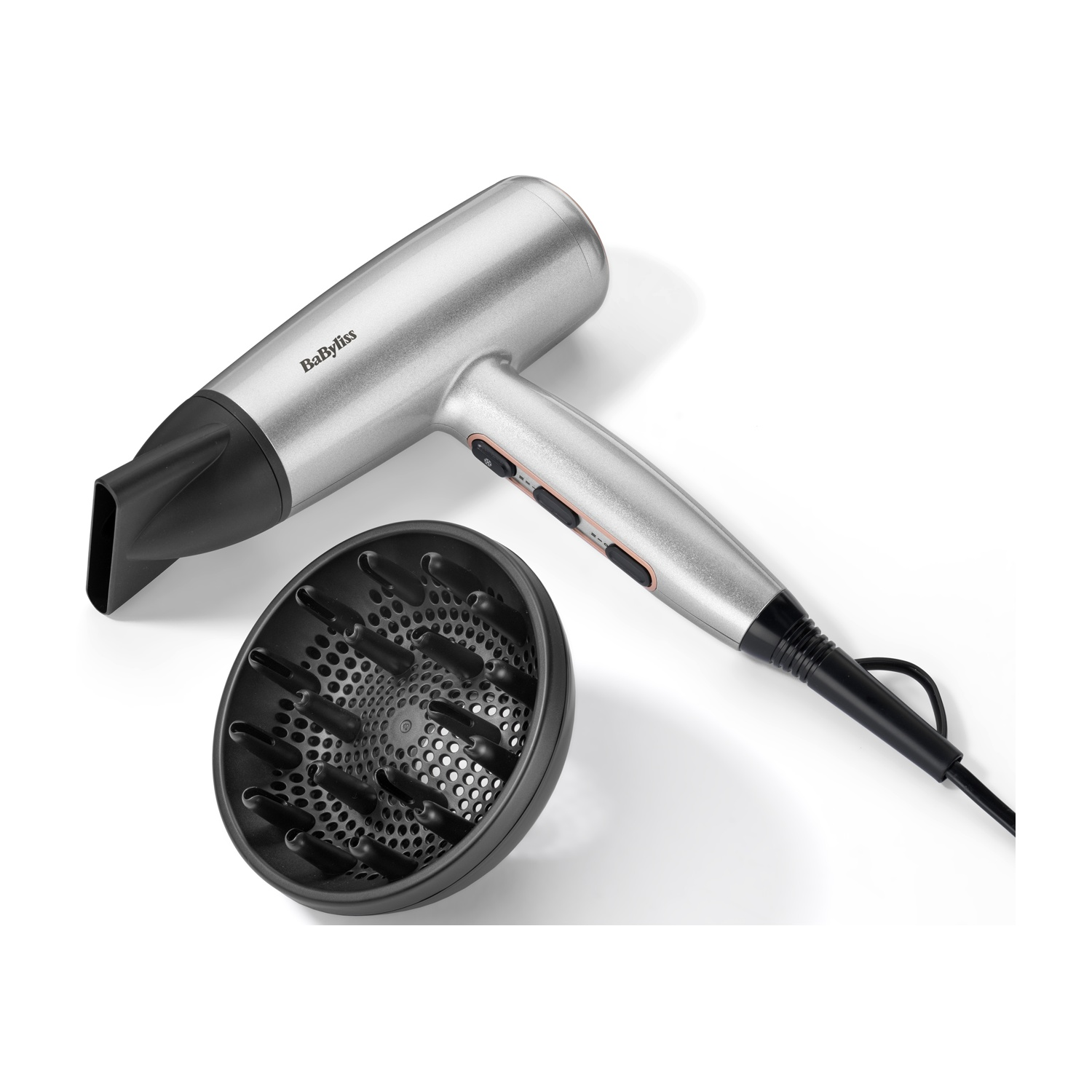 Asciugacapelli Babyliss argentato con ugello nero e diffusore su sfondo bianco. L'asciugacapelli è parzialmente visibile.