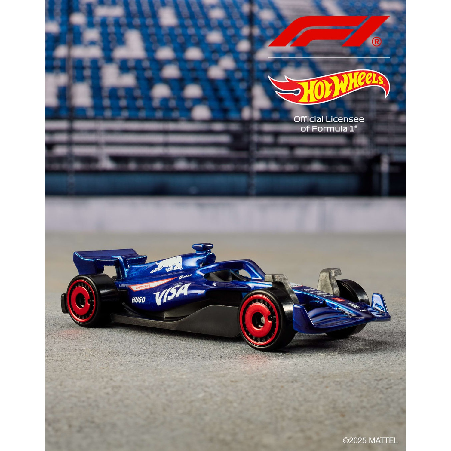Un'auto blu Hot Wheels di Formula 1 con ruote rosse su una superficie grigia. Lo sfondo mostra sedili dello stadio blu sfocati.