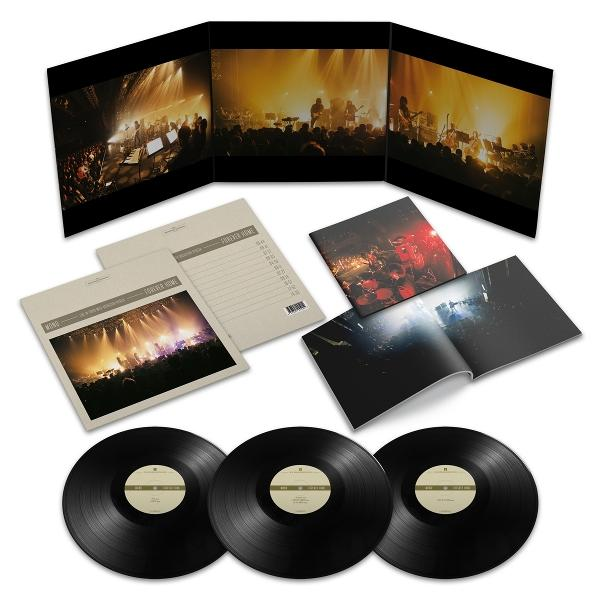 Vinylplatten und Albumcover mit einer Konzernszene. Enthält offene Broschüren, gefaltete Kunstwerke und drei schwarze Platten mit zentralen Etiketten.