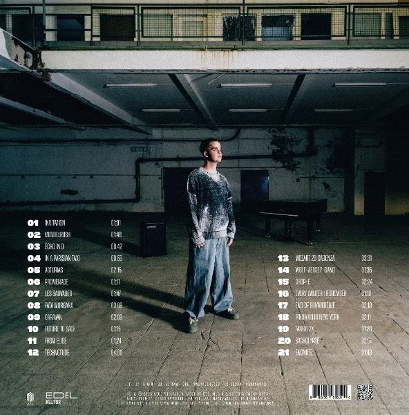 Ein junger Mann steht in einem Lagerhaus. Links ist eine Liste mit Songtiteln. Im Hintergrund steht ein Klavier.