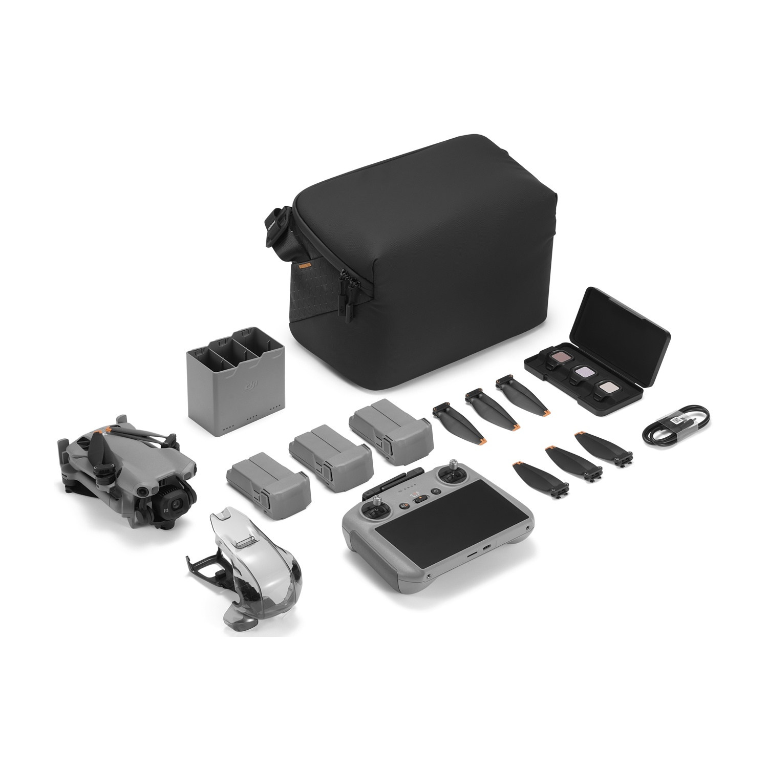 Kit drone con drone, controller, batterie, custodia, eliche e accessori, tutto su sfondo bianco.